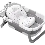 Bañera plegable para bebé gris y blanca con cojín acolchado de puntos y detalle de cocodrilo en el extremo.