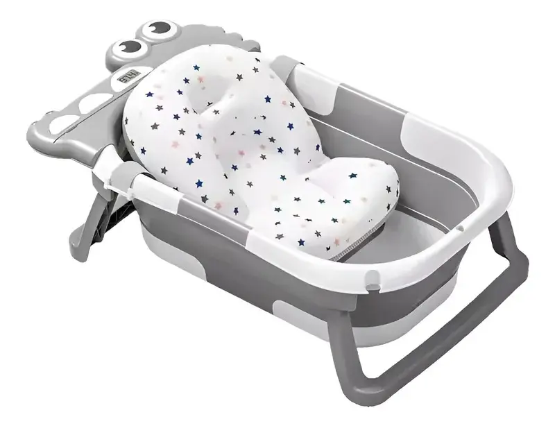 Bañera plegable para bebé gris y blanca con cojín acolchado de puntos y detalle de cocodrilo en el extremo.