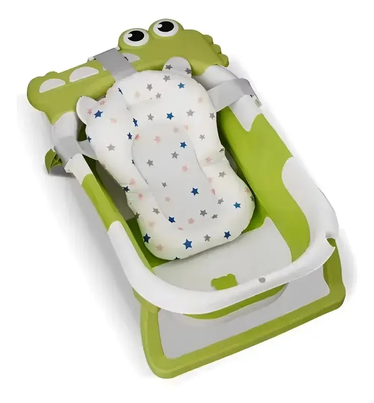 Bañera plegable para bebé verde con diseño de cocodrilo, incluye cojín acolchado blanco con estrellas y correas de sujeción grises.