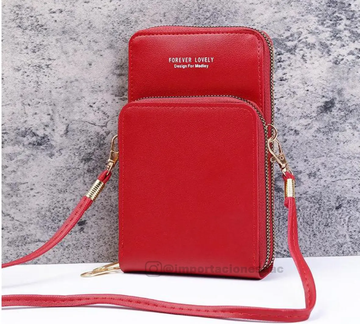 Bolso porta celular rojo cruzado de cuero sintético con doble compartimento independiente con cremallera y correa ajustable dorada.