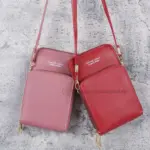 Set de dos bolsos porta celular cruzados con compartimentos, uno color rosa viejo y otro rojo, con correas delgadas y herrajes dorados.
