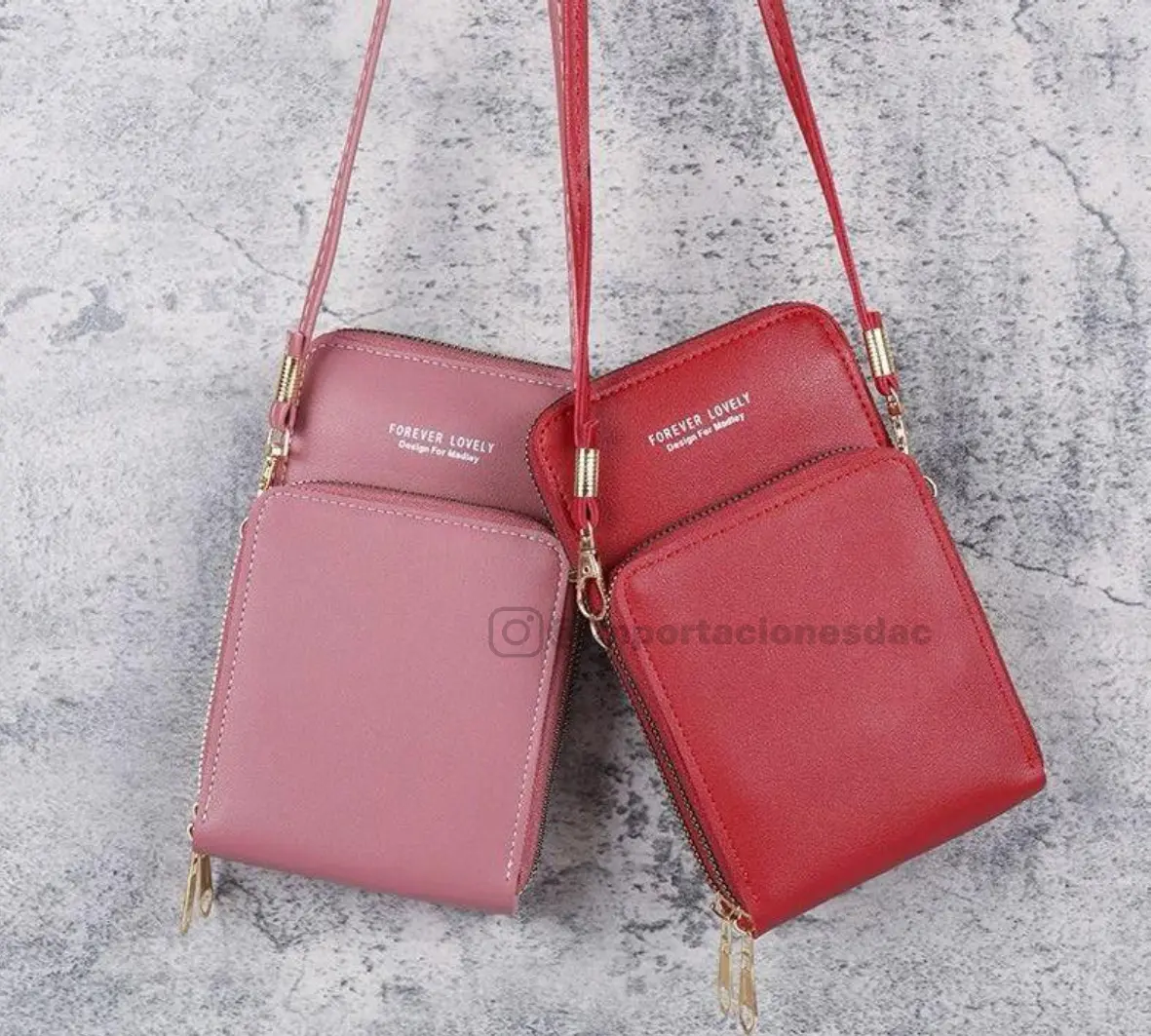 Set de dos bolsos porta celular cruzados con compartimentos, uno color rosa viejo y otro rojo, con correas delgadas y herrajes dorados.
