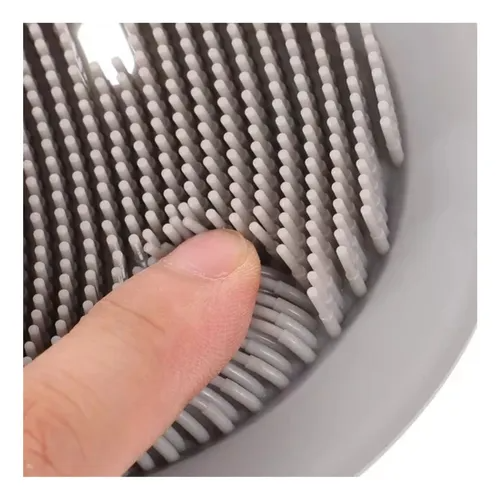 Primer plano de cerdas de silicona blancas y flexibles de un limpiador de pies para ducha, mostrando su textura suave al ser presionadas.