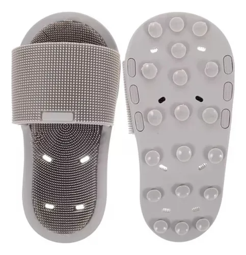Limpiador de pies de silicona gris con textura de relieve y base con ventosas antideslizantes para sujeción en la ducha.