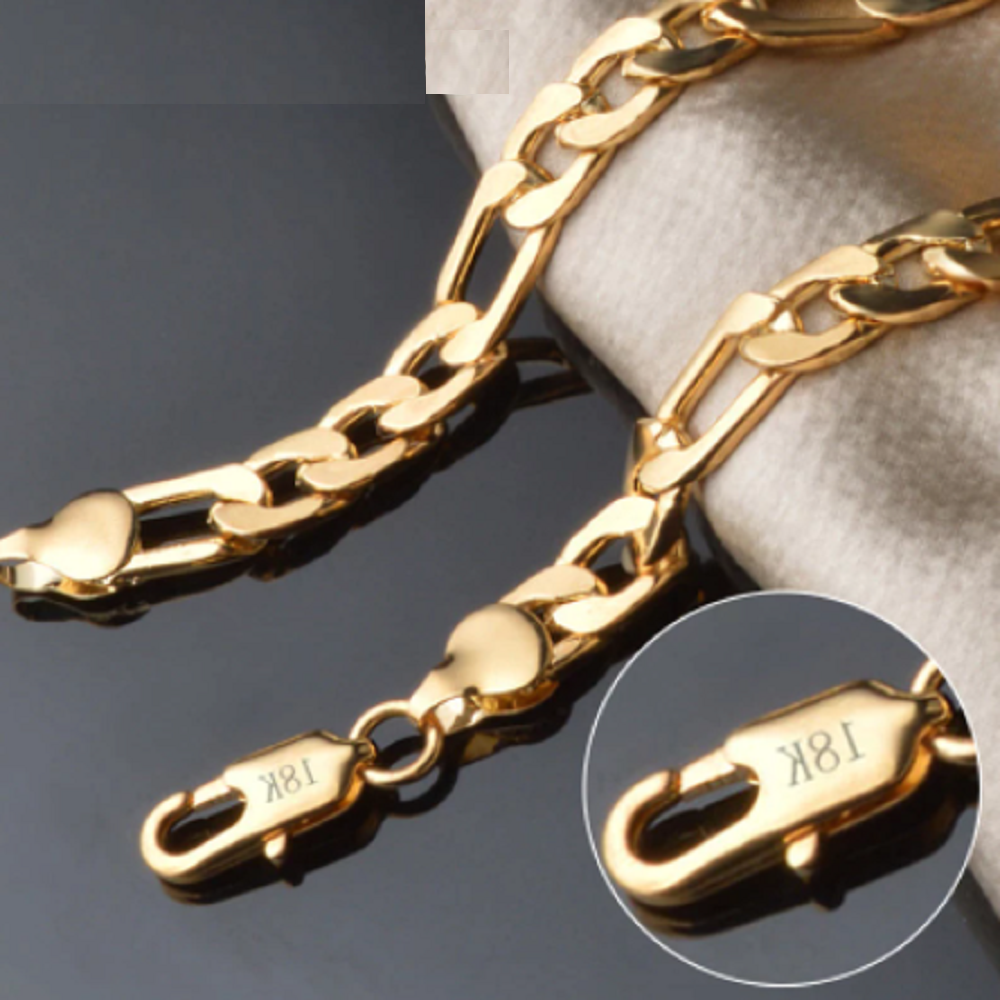 Brazalete Bismark de oro 18K con eslabones entrelazados brillantes y cierre de mosquetón con grabado 18K sobre fondo oscuro y tela clara.