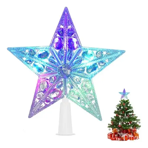 Estrella navideña multicolor con diseño de filigrana y luces LED sobre base blanca, junto a un pequeño árbol para referencia de tamaño.