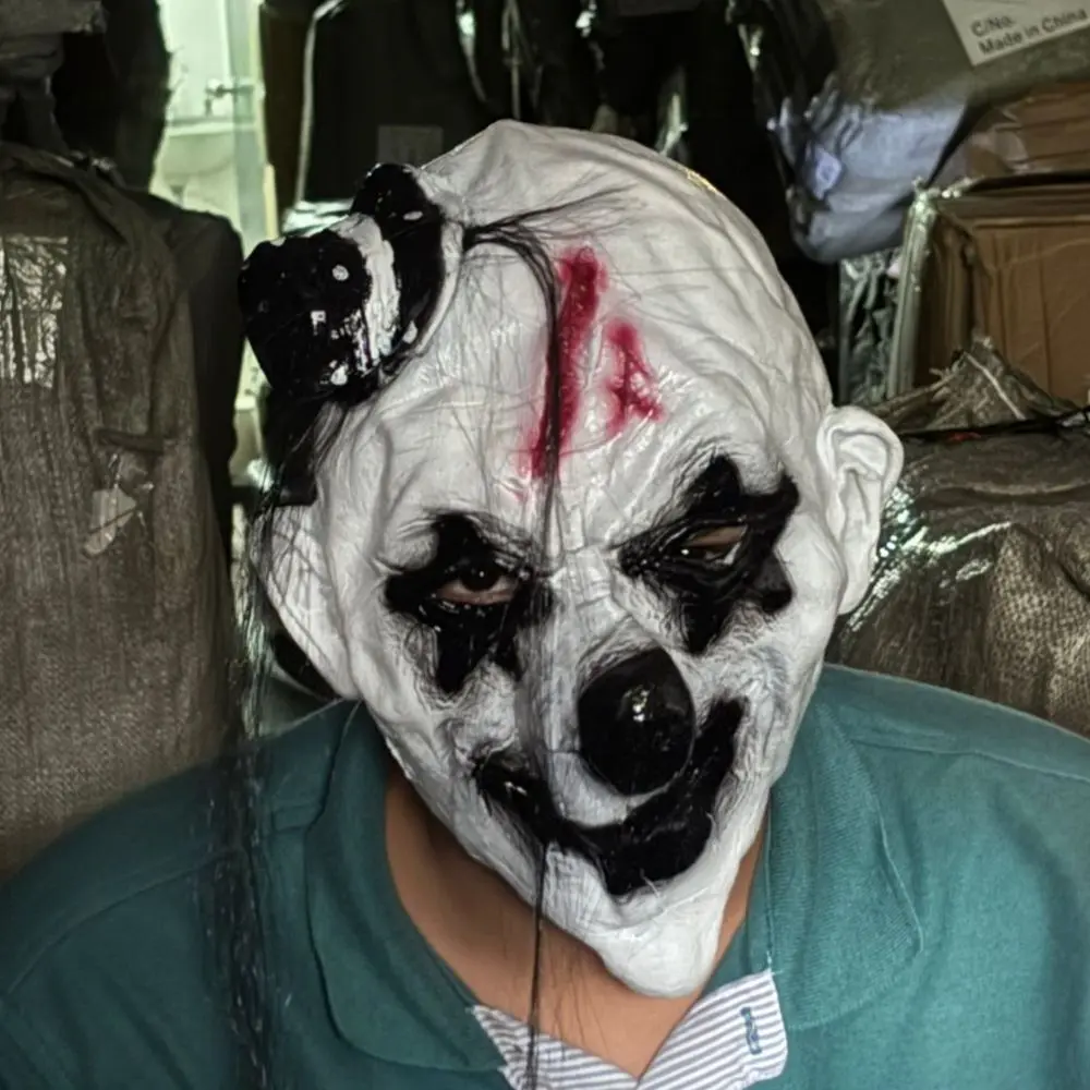 Máscara de payaso aterrador de látex blanco, con maquillaje negro en los ojos, herida sangrienta en la frente, cabello negro y mini sombrero.