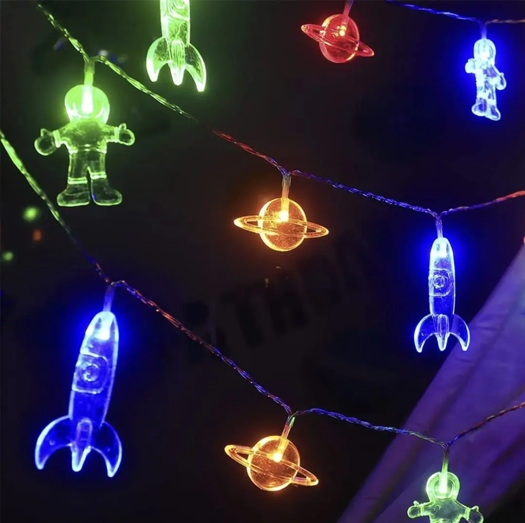 Guirnalda de luces LED decorativas con figuras transparentes de astronautas, cohetes y planetas en varios colores, ideal para habitaciones infantiles.
