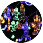 Serie de luces LED decorativas con figuras de astronautas, cohetes y planetas en colores azul, amarillo y verde para fiestas.