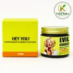 Caja amarilla con base naranja y tarro de vidrio oscuro con tapa dorada de bálsamo de miel y cebo de res Evil Goods, variante Citrus.