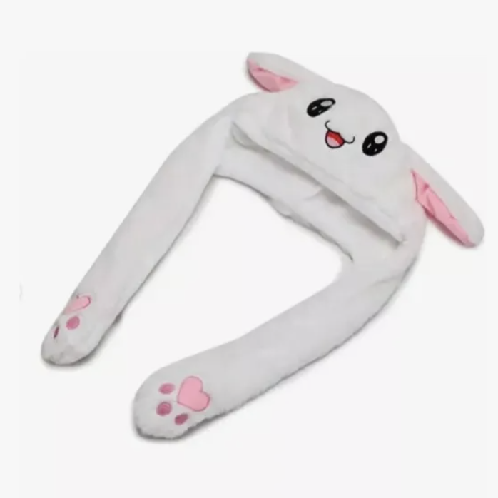 Gorro de peluche blanco con cara de animalito, orejas largas colgantes con huellas de patas rosadas y detalles en rosa.