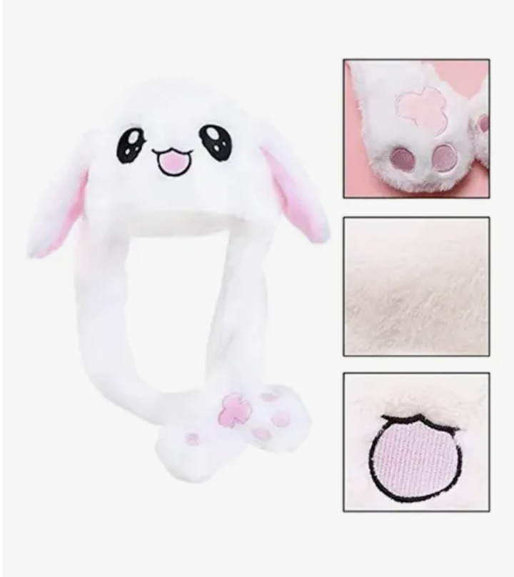 Gorro blanco de felpa suave con cara de animal, ojos bordados, orejas largas con interior rosa y largas patas colgantes con almohadillas rosas.