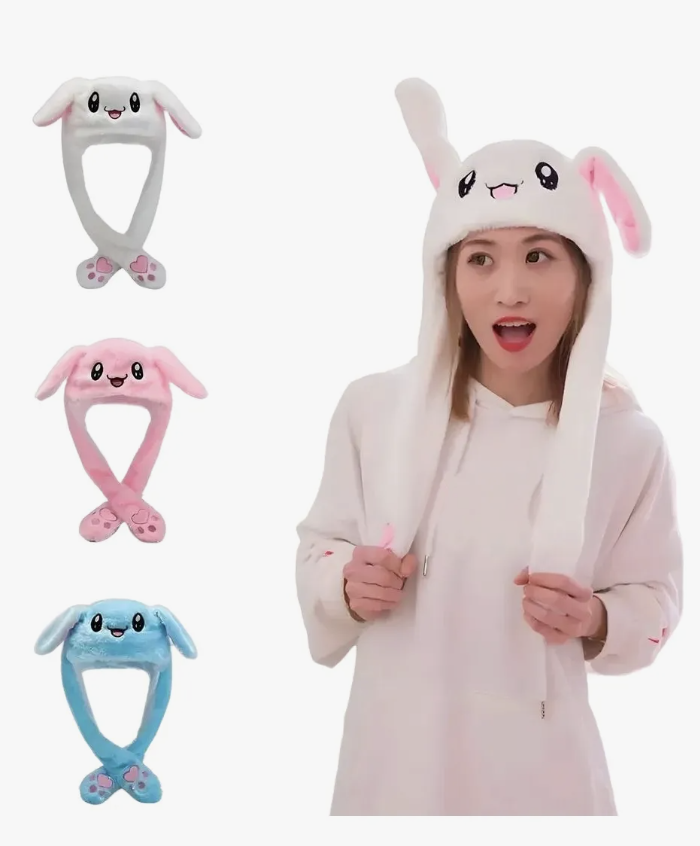 Gorro con orejas móviles de felpa blanca y luz LED. Mujer sonriente con polerón blanco viste la variante blanca del gorro en uso.