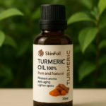 Frasco ámbar de 30 ml de aceite esencial de cúrcuma sobre superficie beige, con etiqueta blanca y hojas verdes desenfocadas de fondo.