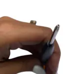 Primer plano de destornillador Torx T8 con punta de seguridad metálica y mango negro, sostenido por una mano para reparaciones electrónicas.