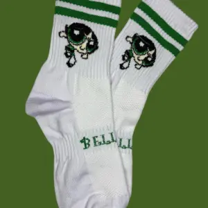 Par de medias blancas de media caña con dos líneas verdes, diseño de Buttercup y la marca Bellis impresa en verde sobre la zona acolchada del empeine