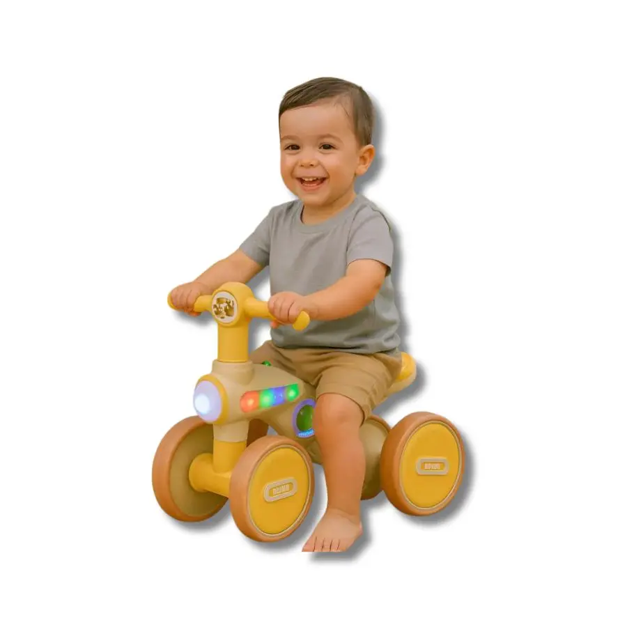 Niño pequeño montado en triciclo infantil de 4 ruedas color amarillo con luces LED y panel musical para estimular su coordinación motriz.