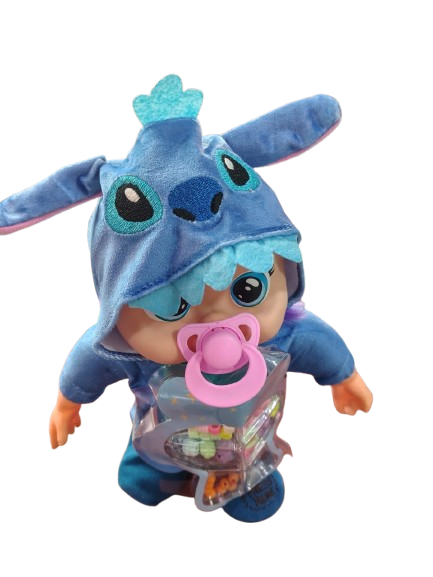 Muñeco bebé llorón articulado con disfraz azul de Stitch, capucha con orejas, chupete rosa y estuche transparente con accesorios variados en el pecho.