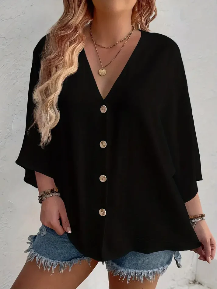 Blusa negra de cuello V con botones frontales y mangas amplias tipo capa, de estilo casual y caída fluida.