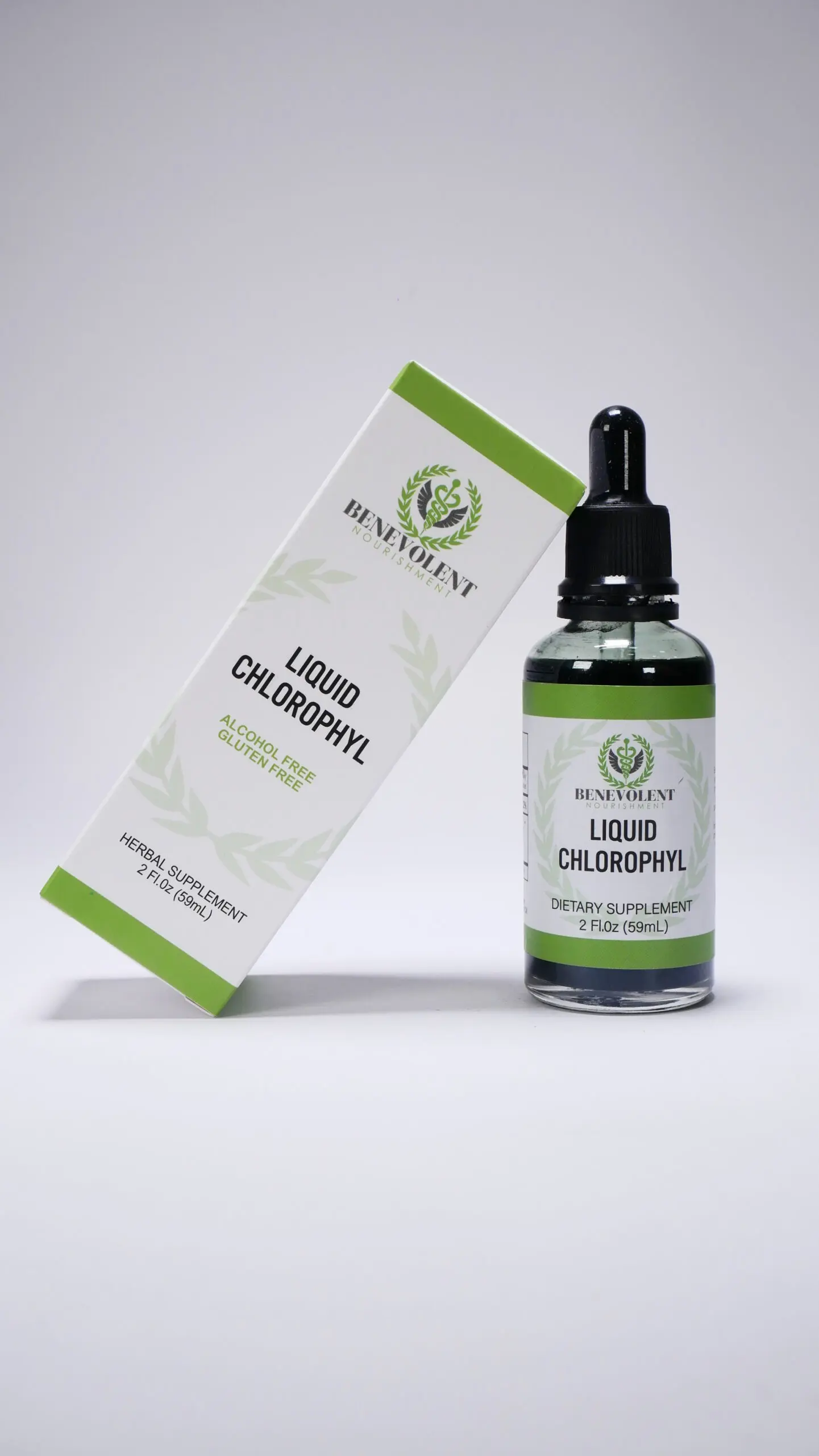 Caja blanca inclinada junto a frasco de vidrio con gotero negro de Clorofila Líquida Benevolent de 2 oz (59 ml) con detalles de hojas verdes.