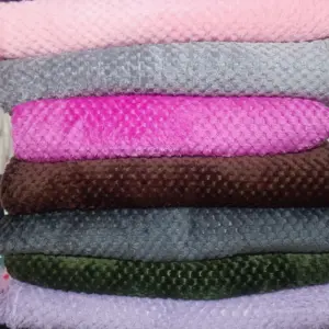 Pila de cobijas tipo piña suaves y ligeras en colores azul, rosado, gris, fucsia, café, verde oscuro, lila y negro.