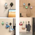 Ganchos adhesivos con diseño de gato en blanco, negro, verde y rosa, usados para colgar llaves, bolsos, tazas y accesorios en diversos ambientes.