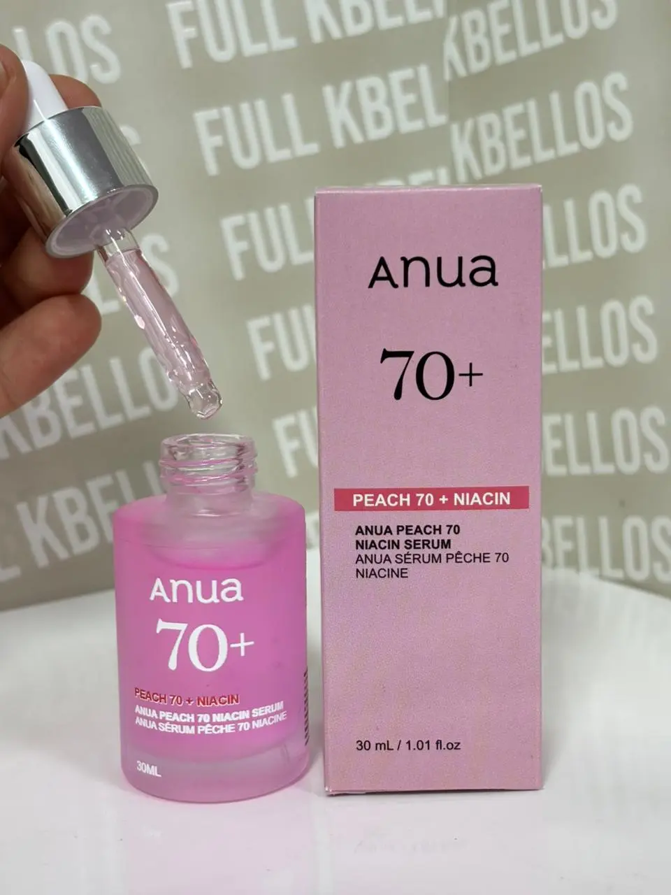 Suero facial iluminador Anua Peach 70 Niacin 30 ml en frasco rosado translúcido con gotero elevado y caja rosada de empaque.
