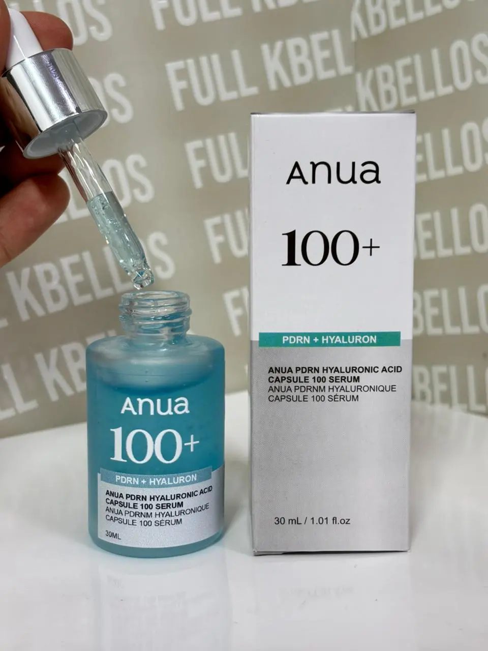 Serum facial Anua 100+ PDRN con hialurónico de 30 ml en botella azul con gotero y caja plateada abierta.