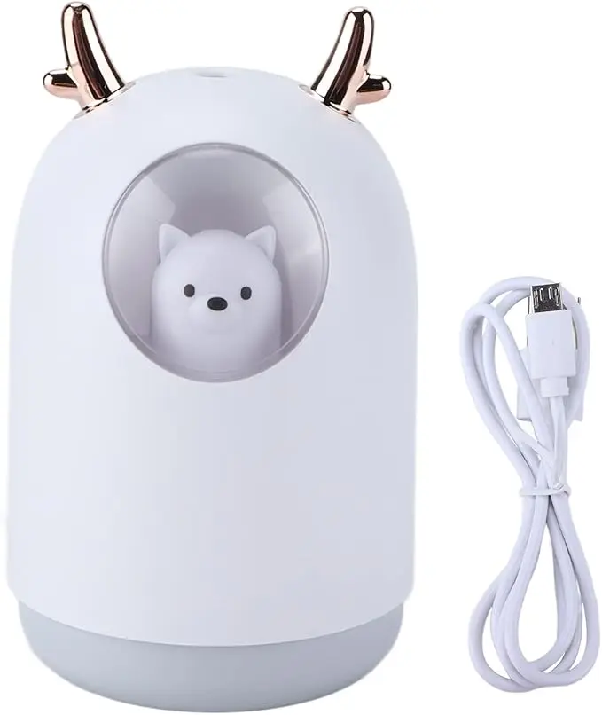 Humidificador ultrasónico blanco con diseño de oso en ventana circular, cuernos dorados y cable USB incluido.