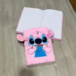 Libreta rosa afelpada de Stitch con peluche suave en relieve, diseño tierno y hojas interiores con líneas horizontales sobre superficie de madera.