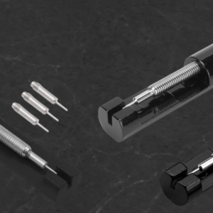 Herramienta negra para ajustar eslabones de reloj, con tornillo metálico roscado, mango estriado y tres punzones de repuesto incluidos.
