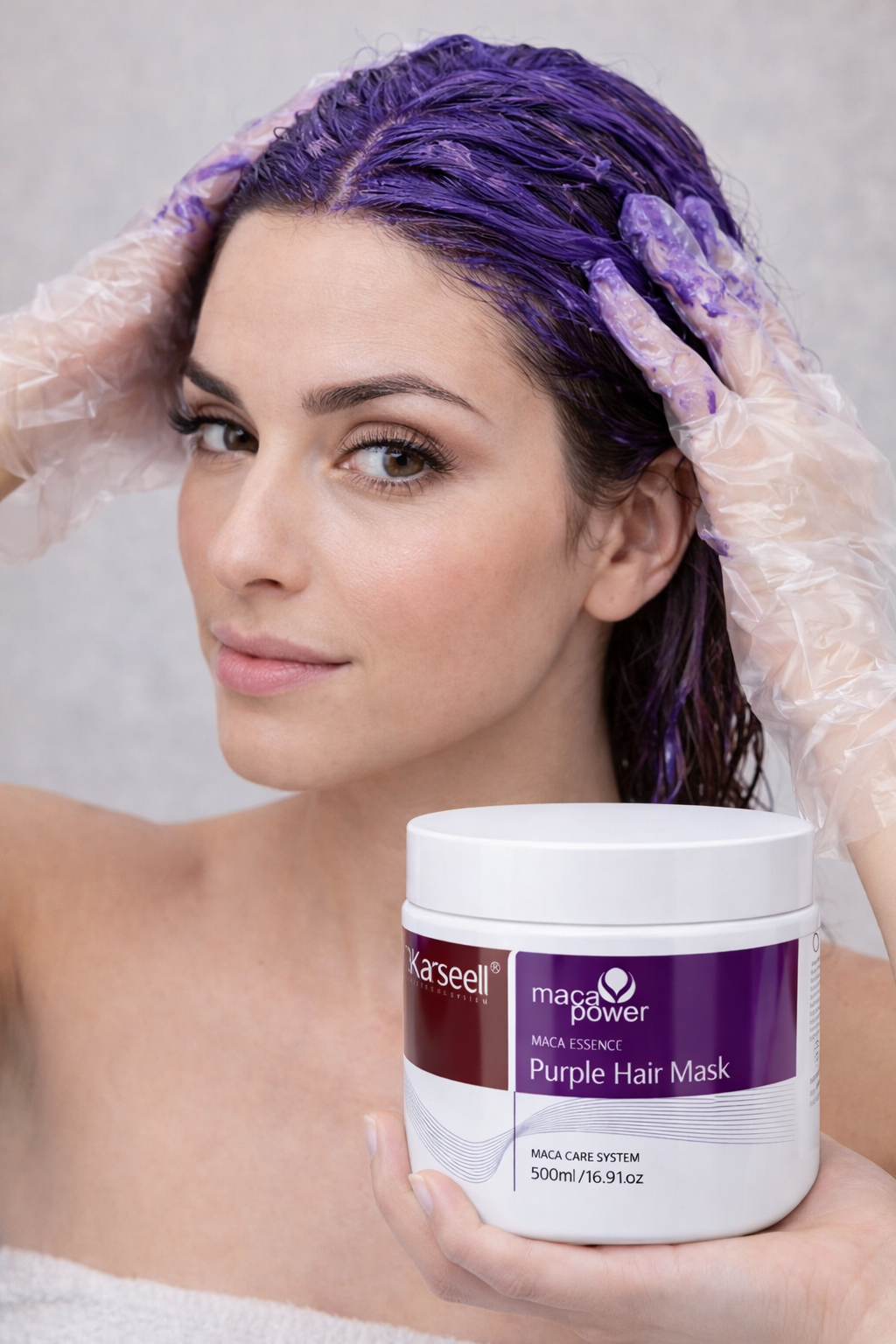 Mujer aplicando mascarilla morada de maca en su cabello con guantes transparentes, mostrando el envase blanco de quinientos mililitros.