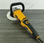 Polichadora rotativa amarilla y negra con mango tipo D, control de velocidad y almohadilla blanca para pulido automotriz sobre fondo gris.