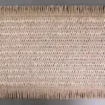 Dos manteles individuales de fibras naturales tejidas en tono beige y crudo con acabado rústico y flecos en los extremos superior e inferior.
