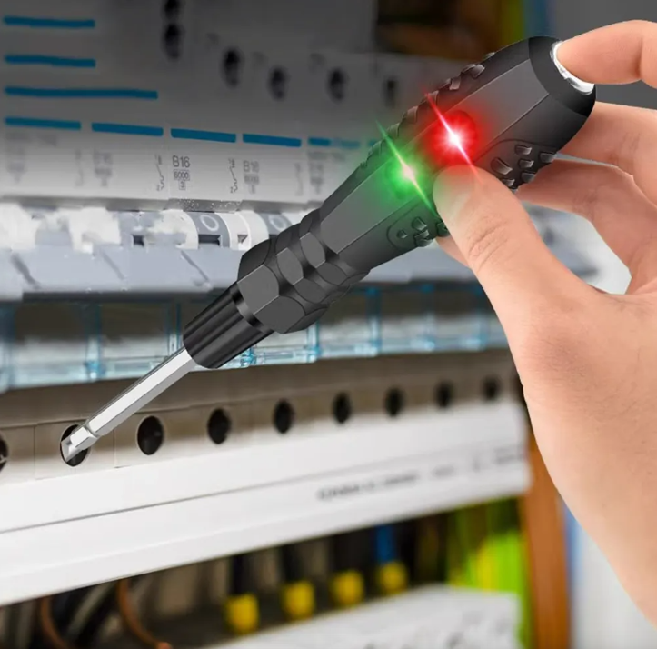 Destornillador probador de voltaje negro con indicadores LED verde y rojo en uso sobre un panel de interruptores eléctricos.