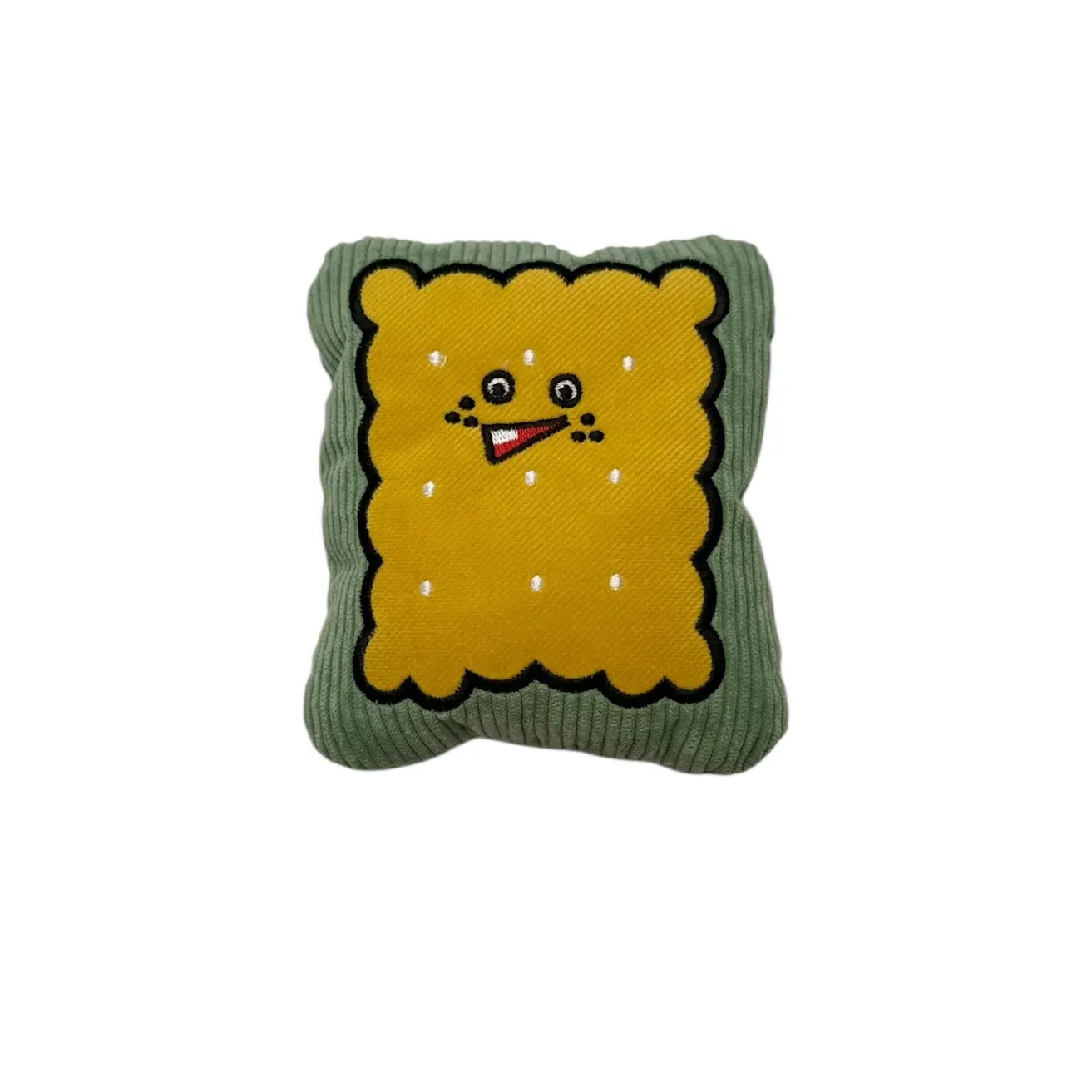 Peluche para perros con forma de galleta cuadrada, textura de pana verde, centro amarillo con bordado de cara sonriente y puntos blancos, ideal para juego.