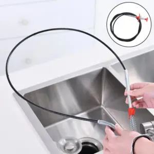 Destapador de cañerías flexible negro con garra metálica y mango rojo, usado sobre un lavaplatos de acero inoxidable.