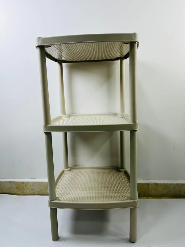 Repisa organizadora de tres niveles en plástico color beige con estantes de superficie texturizada y bordes elevados tipo bandeja.