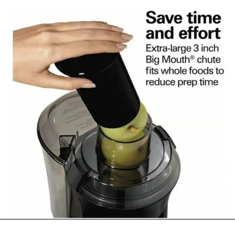Extractor eléctrico negro de 800W con boca ancha de 3 pulgadas y mano introduciendo manzana verde en el tubo alimentador.