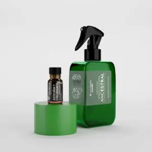 Tónico capilar anticaída verde en botella con atomizador junto a frasco pequeño sobre base cilíndrica.