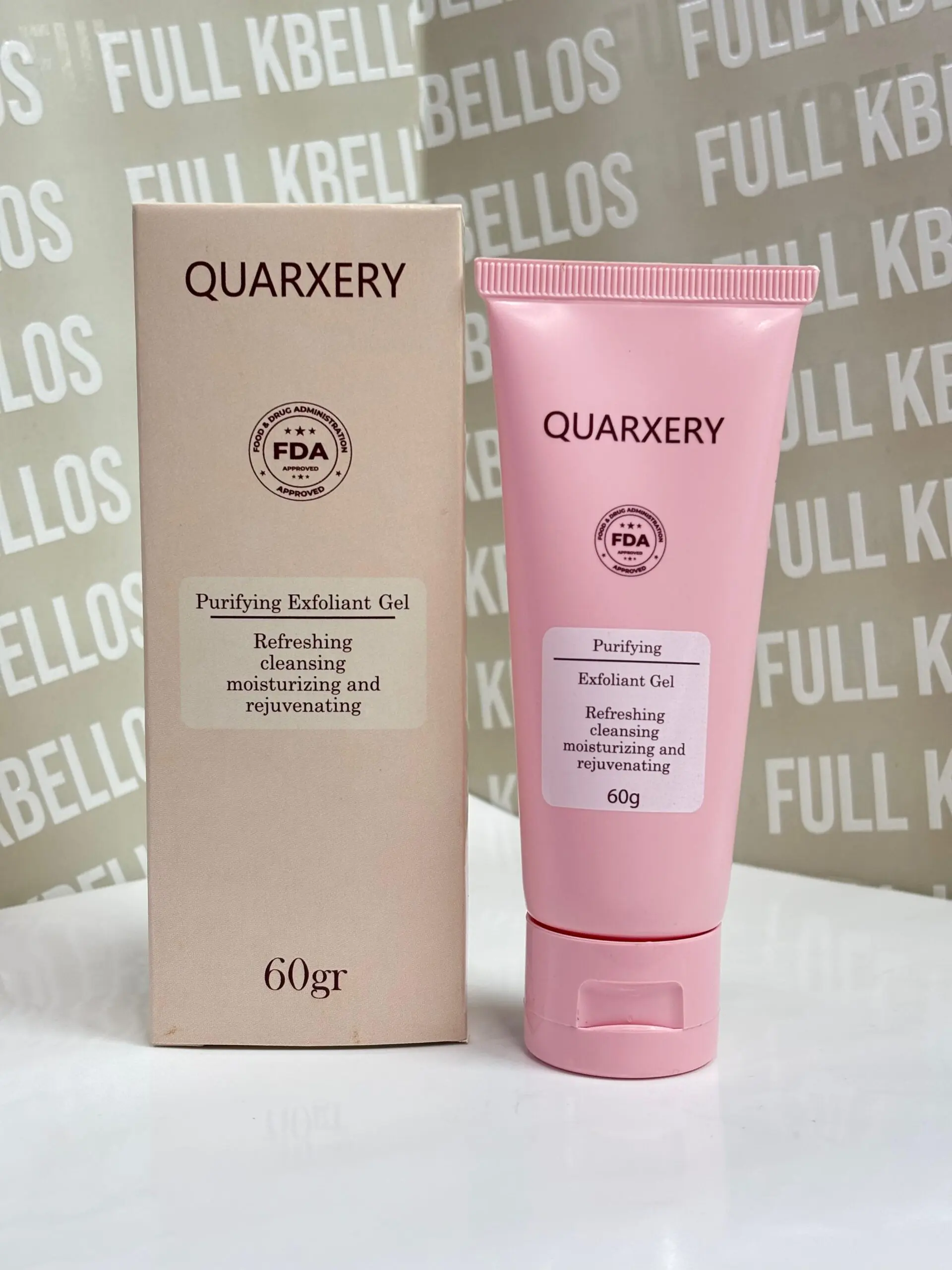 Caja y tubo rosados de gel exfoliante facial Quarxery de 60 gramos, sobre superficie blanca con fondo con letras.