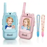 Walkie talkie infantil con cámara y pantalla, disponible en color azul y rosado, con dos cordones colgantes estampados.