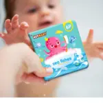 Libro de baño impermeable celeste de PVC con diseño de pulpo rosado en bañera espumosa, ideal para la ducha de bebés.