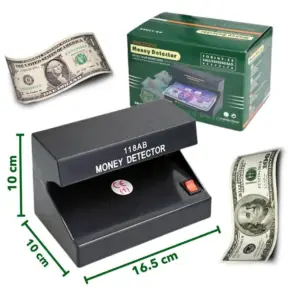 Detector de billetes falsos 118AB negro de 16.5x10x10 cm con luz ultravioleta, interruptor rojo y caja verde, acompañado de dos billetes de dólar.