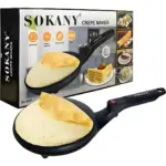 Crepera eléctrica Sokany negra con superficie antiadherente, incluye caja del producto y una crepe cocinándose sobre la placa de inmersión.