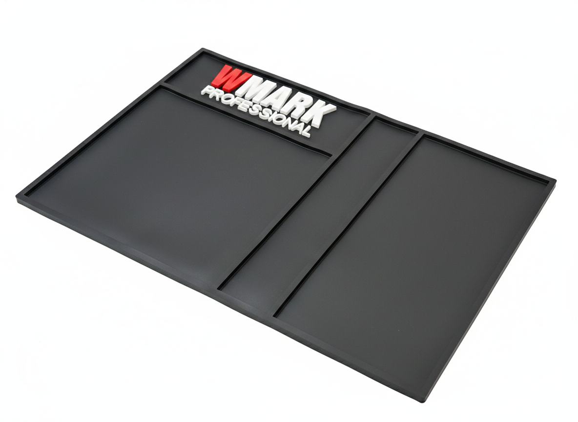 Tapete organizador negro WMARK Professional para barbería con tres compartimentos delimitados por relieves y acabado antideslizante en perspectiva.