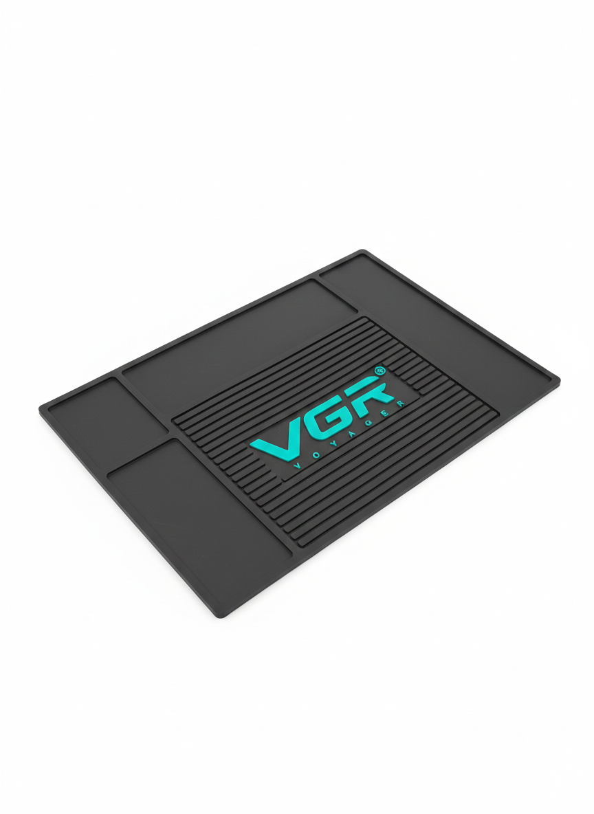 Tapete organizador negro antideslizante para barbería con logo VGR en cian, textura de estrías y compartimentos, mostrado en perspectiva.
