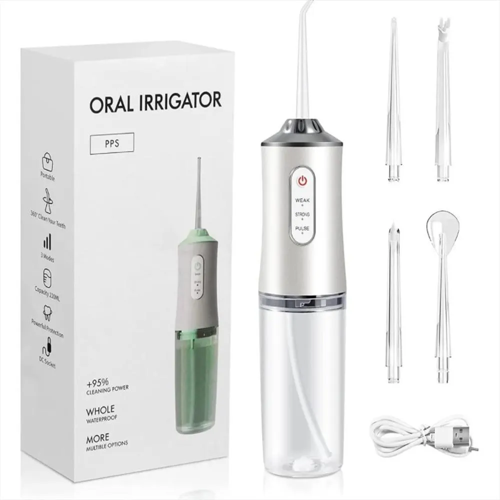 Irrigador dental portátil plateado con tanque transparente, caja, cuatro boquillas intercambiables y cable de carga USB.