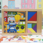 Tabla Tangram Montessori de madera con piezas de medios de transporte coloridas y bloques geométricos sobre base de madera y fondo pintado.