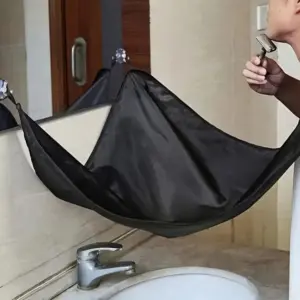 Capa atrapa barba negra de tela impermeable suspendida con ventosas en el espejo para evitar ensuciar el lavamanos mientras un hombre se afeita